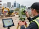 Topographical land surveys London depicted with a surveyor using advanced equipment on a construction site.