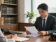 Law consultation with attorney reviewing documents and client listening at a desk in a modern office, highlighting site web for legal services.